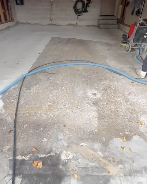 Before: bare, stained concrete garage floor during grinding
